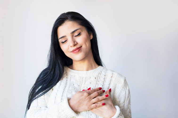 a woman with her hands over her heart