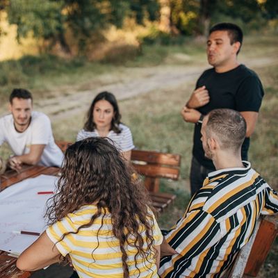 Four adults listening to a meeting facilitator